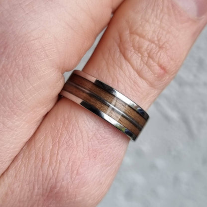 Stainless steel and walnut ring with guitar string inlay